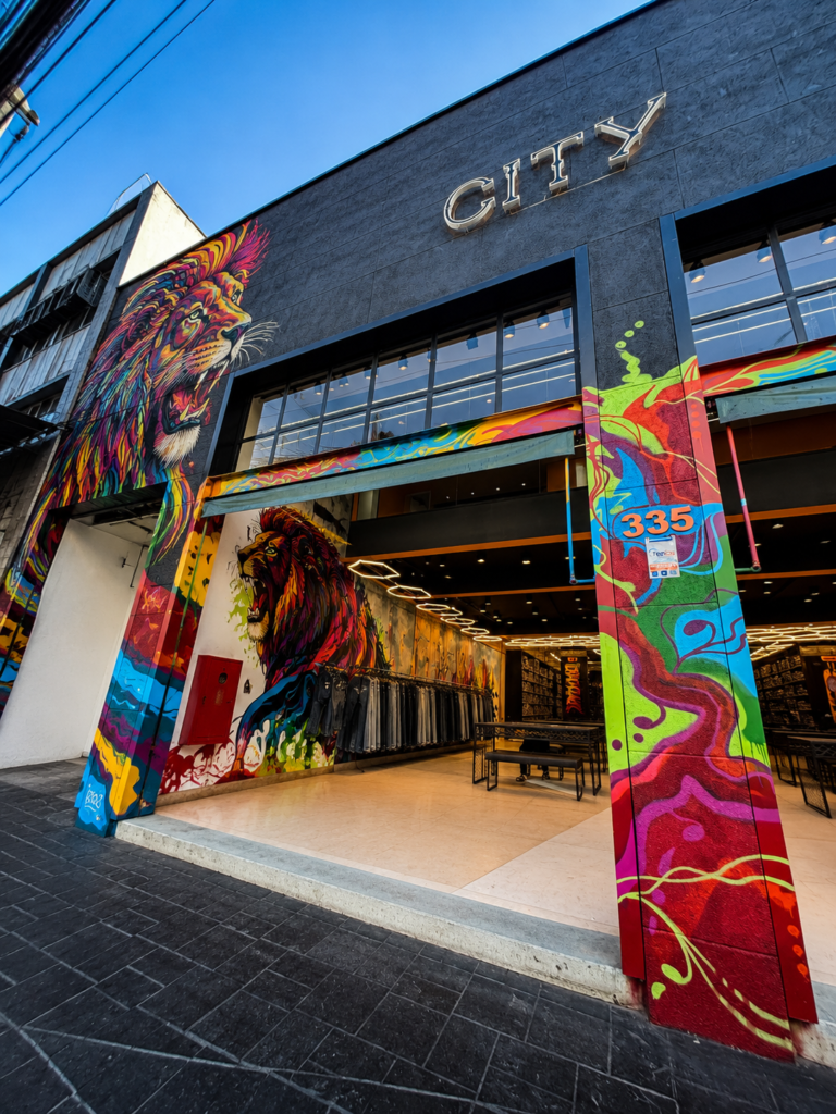 Fachada da City Denim 86, com murais coloridos e entrada da loja.
